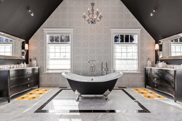 bathroom with lofted ceiling, a soaking tub, plenty of natural light, and vanity