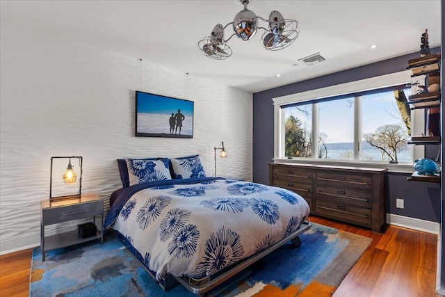 bedroom featuring recessed lighting, visible vents, baseboards, and wood finished floors