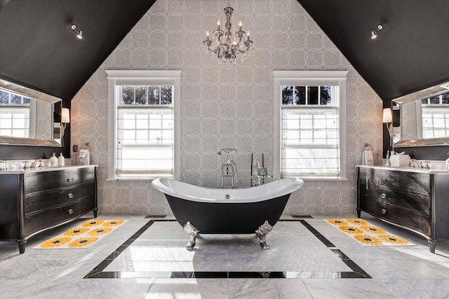 full bathroom with a wealth of natural light, a soaking tub, an inviting chandelier, and vaulted ceiling