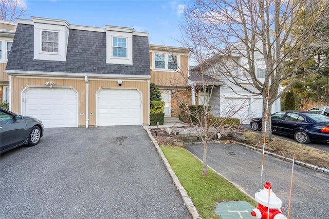 townhome / multi-family property featuring a garage, a shingled roof, and aphalt driveway