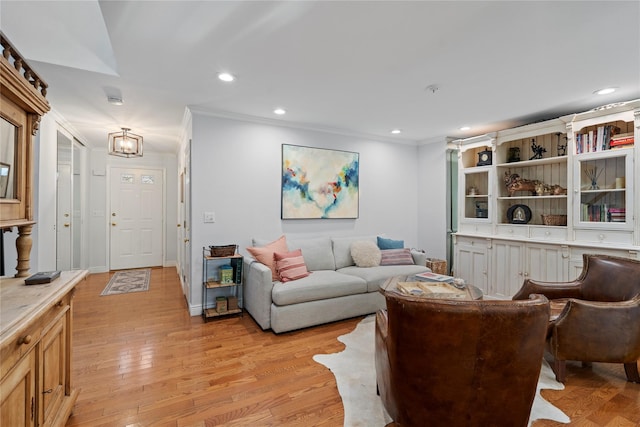 living room with light wood finished floors, ornamental molding, and recessed lighting