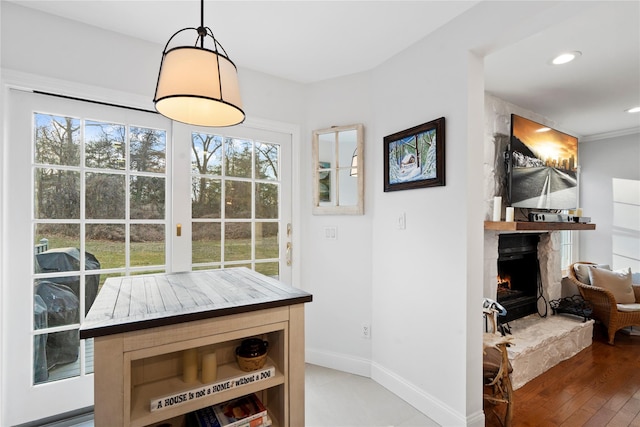 dining space featuring recessed lighting, a fireplace, baseboards, and wood finished floors