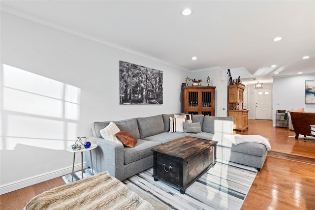 living area featuring baseboards, light wood-style floors, recessed lighting, and crown molding