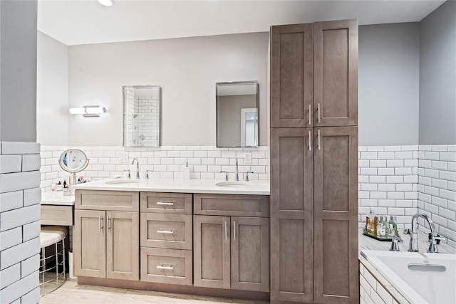 bathroom with a sink, tile walls, and a bath