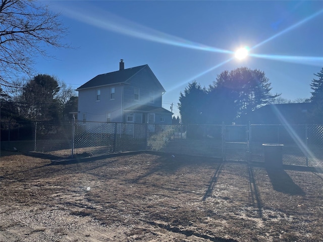 rear view of house featuring fence and a chimney