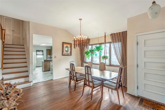 dining area with baseboards, a chandelier, stairway, lofted ceiling, and wood finished floors