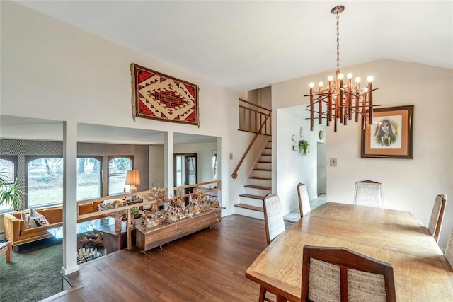 dining room featuring vaulted ceiling, stairway, a chandelier, and wood finished floors