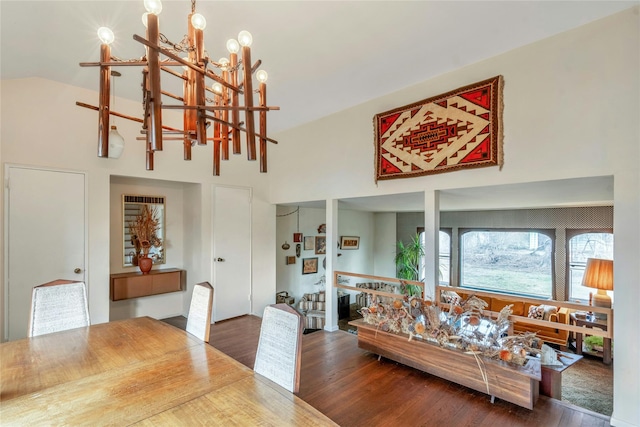 dining space featuring a high ceiling, an inviting chandelier, and wood finished floors