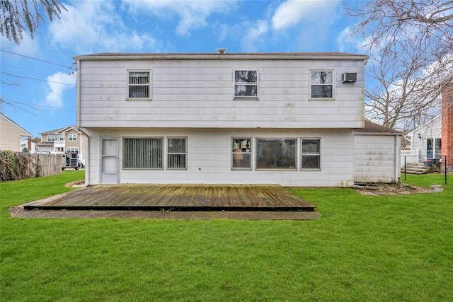 back of property featuring a deck, a lawn, and fence