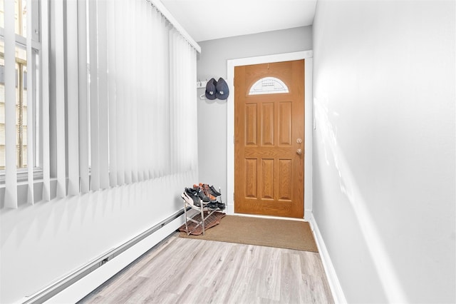 doorway with a baseboard radiator, baseboards, and wood finished floors