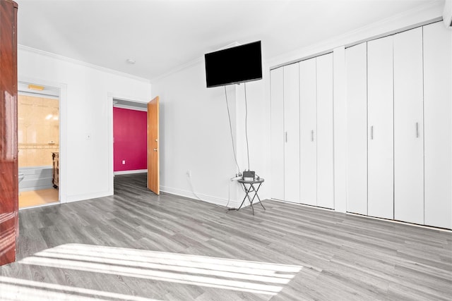 interior space with a closet, crown molding, baseboards, and wood finished floors