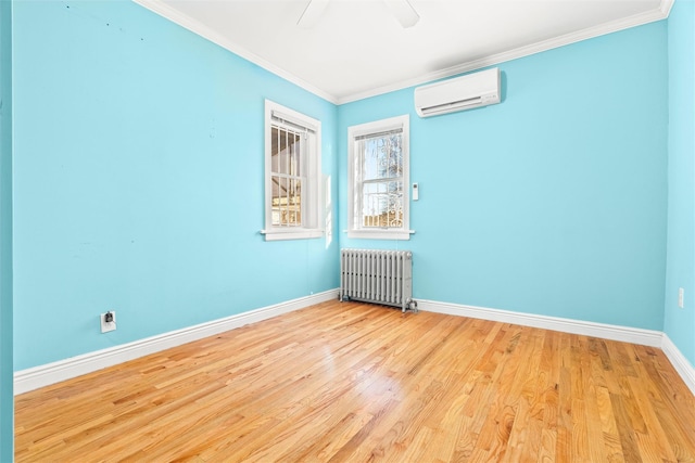 spare room with wood finished floors, radiator heating unit, a wall mounted AC, and crown molding