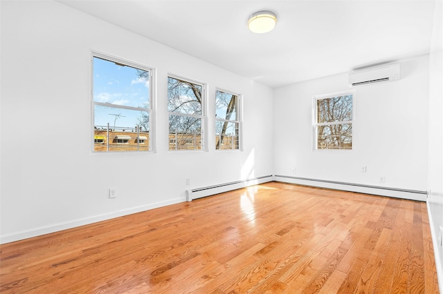 unfurnished room featuring a wall unit AC, baseboards, and wood finished floors