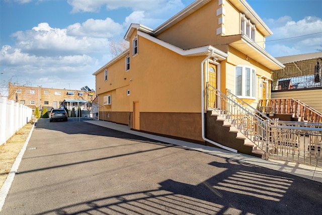 view of property exterior featuring fence and stucco siding