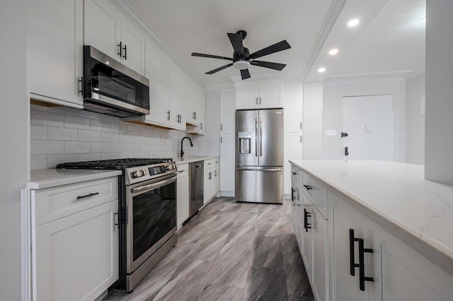 kitchen featuring recessed lighting, white cabinetry, appliances with stainless steel finishes, decorative backsplash, and crown molding