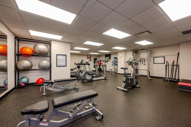 exercise room featuring baseboards, visible vents, and a drop ceiling