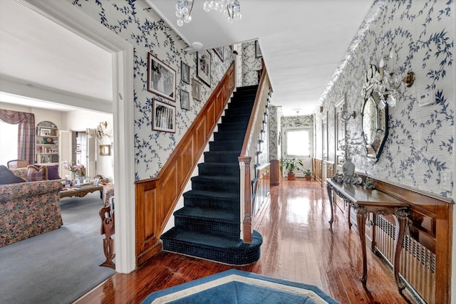 stairs with hardwood / wood-style floors, wainscoting, and wallpapered walls