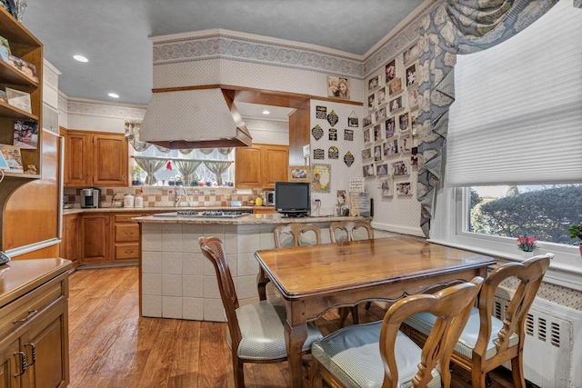 dining area with crown molding, a wealth of natural light, and wallpapered walls