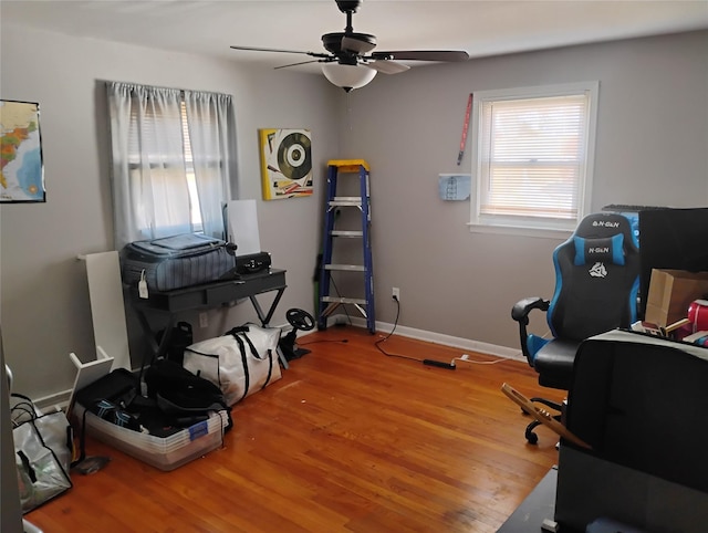 office space with baseboards, wood finished floors, and a ceiling fan