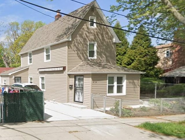 view of front of property featuring a chimney and fence