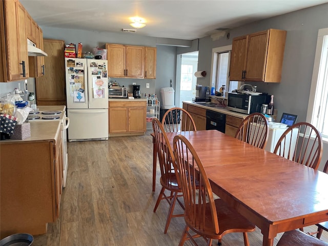 dining room featuring light wood finished floors, visible vents, and a toaster