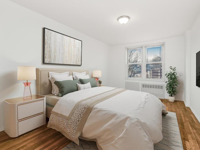 bedroom featuring radiator heating unit and wood finished floors