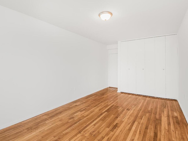 unfurnished bedroom with a closet and light wood-style flooring