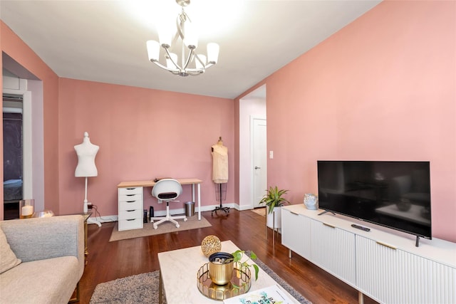 living area with baseboards, an inviting chandelier, and wood finished floors