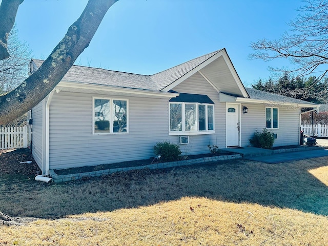 single story home featuring fence, a front lawn, and roof with shingles