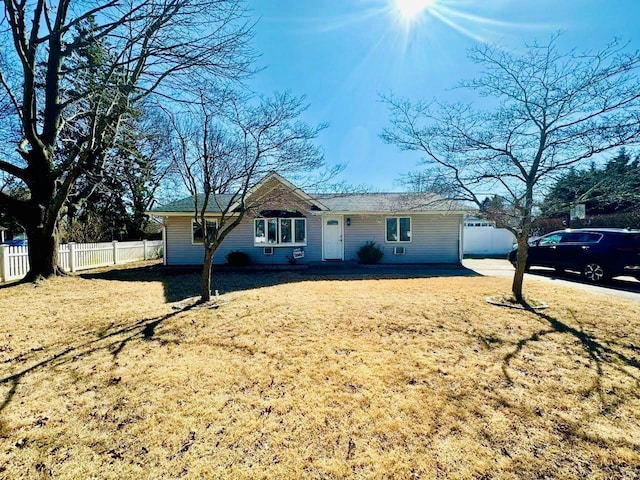 ranch-style house featuring fence and a front lawn