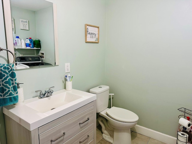 bathroom featuring washer / dryer, baseboards, toilet, tile patterned flooring, and vanity