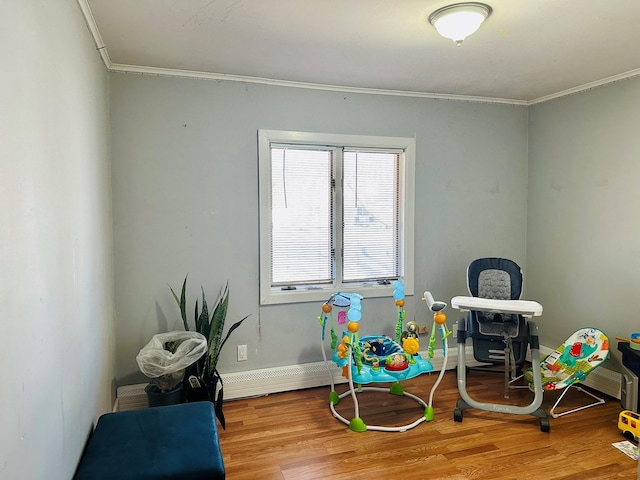 playroom with ornamental molding, baseboards, and wood finished floors