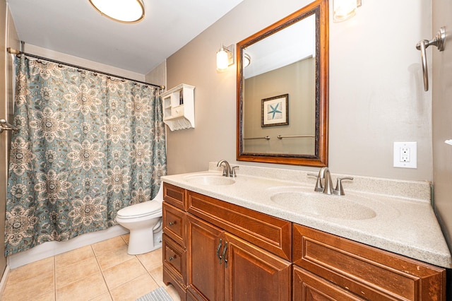 bathroom with toilet, tile patterned flooring, double vanity, and a sink