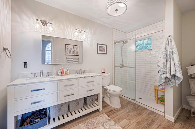 full bath with wood finished floors, a sink, toilet, and a shower stall