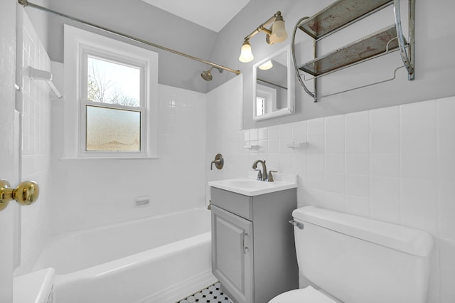 full bath with toilet, tub / shower combination, vanity, and tile walls