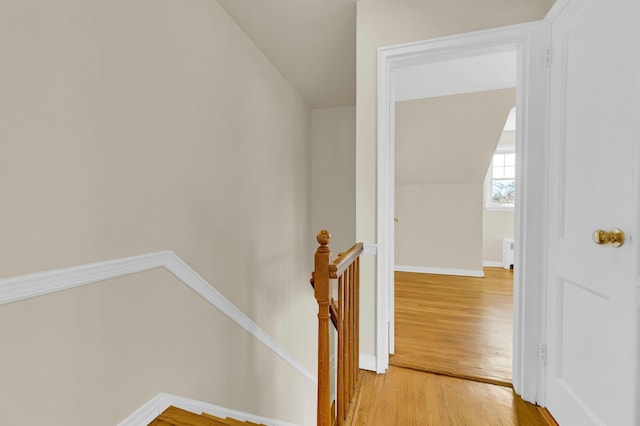 stairs with lofted ceiling, baseboards, and wood finished floors