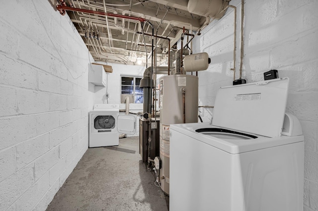 washroom featuring gas water heater, laundry area, independent washer and dryer, and concrete block wall