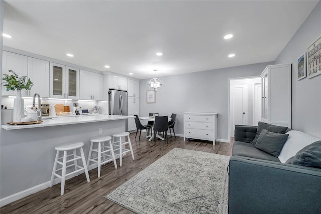 living room with baseboards, dark wood finished floors, and recessed lighting