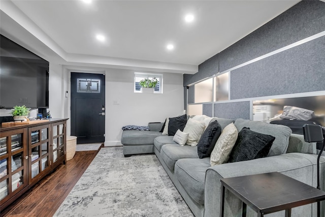 living area with an accent wall, recessed lighting, dark wood finished floors, and baseboards