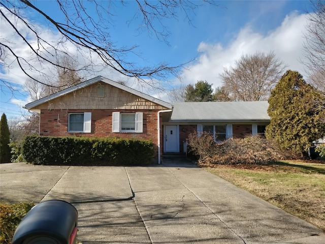 view of front of house featuring driveway and brick siding