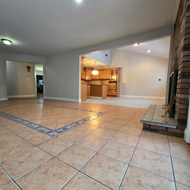 unfurnished living room with vaulted ceiling with beams, a brick fireplace, baseboards, and light tile patterned flooring