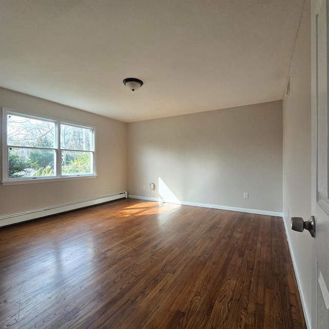 unfurnished room with a baseboard heating unit, dark wood finished floors, and baseboards