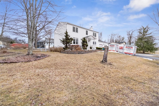 view of front of home with driveway, a chimney, and an attached garage