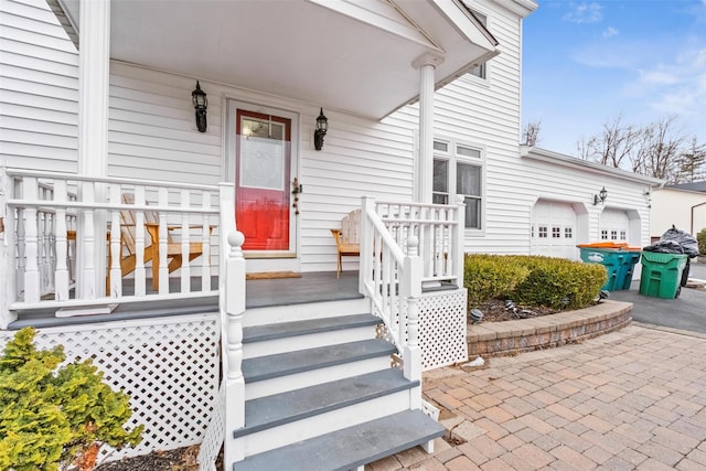 entrance to property featuring a porch and a garage