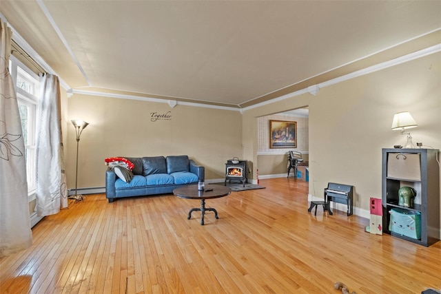 living room featuring a wood stove, hardwood / wood-style flooring, baseboard heating, and crown molding