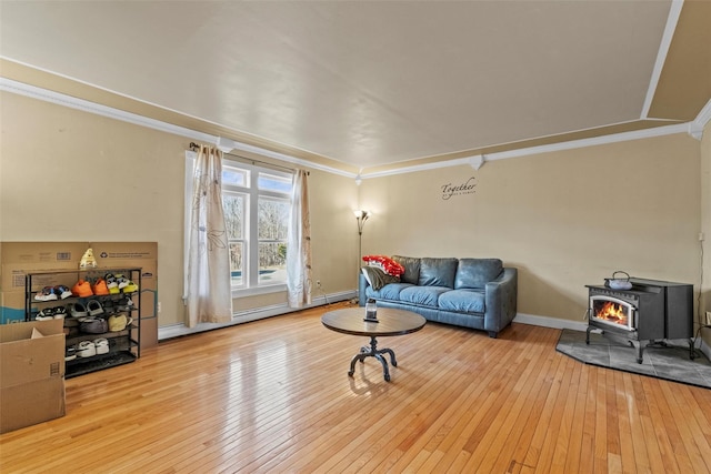 living room with ornamental molding, hardwood / wood-style flooring, and baseboards