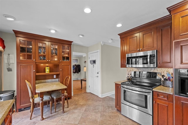 kitchen featuring light tile patterned floors, recessed lighting, stainless steel appliances, light countertops, and backsplash