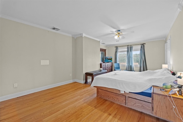 bedroom featuring light wood-style flooring, visible vents, ornamental molding, and baseboards