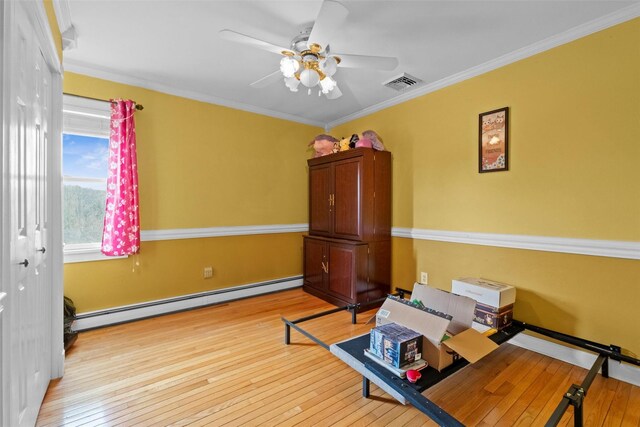 bedroom with ornamental molding, hardwood / wood-style floors, a baseboard radiator, and visible vents