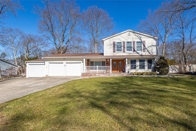 traditional-style house featuring a garage, covered porch, concrete driveway, and a front yard